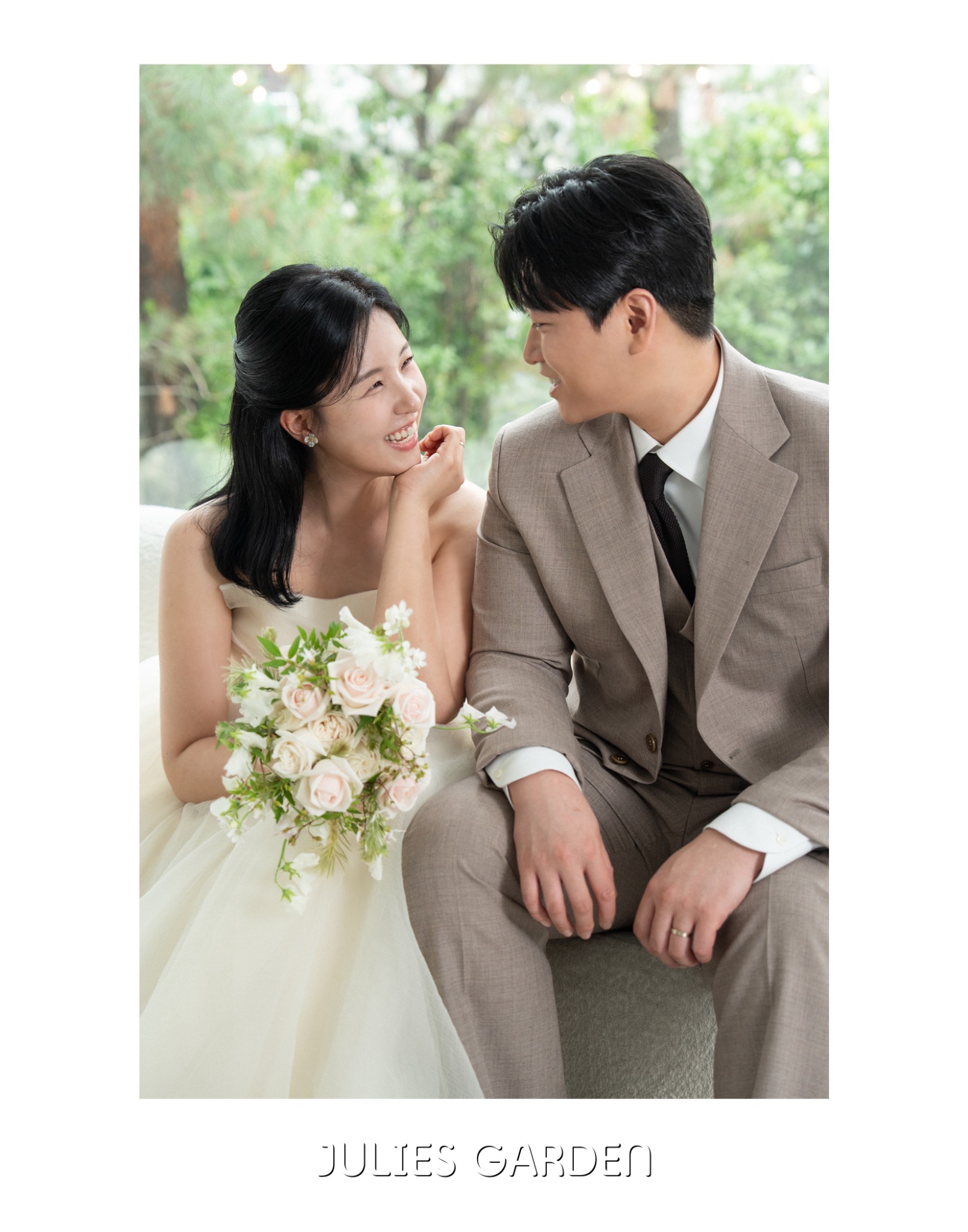 나란히 앉아 서로를 바라보며 환하게 웃는 예비부부